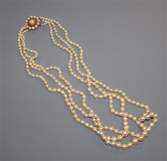 A triple strand graduated cultured pearl necklace with 9ct, cultured pearl and garnet set clasp, approx. 52cm.